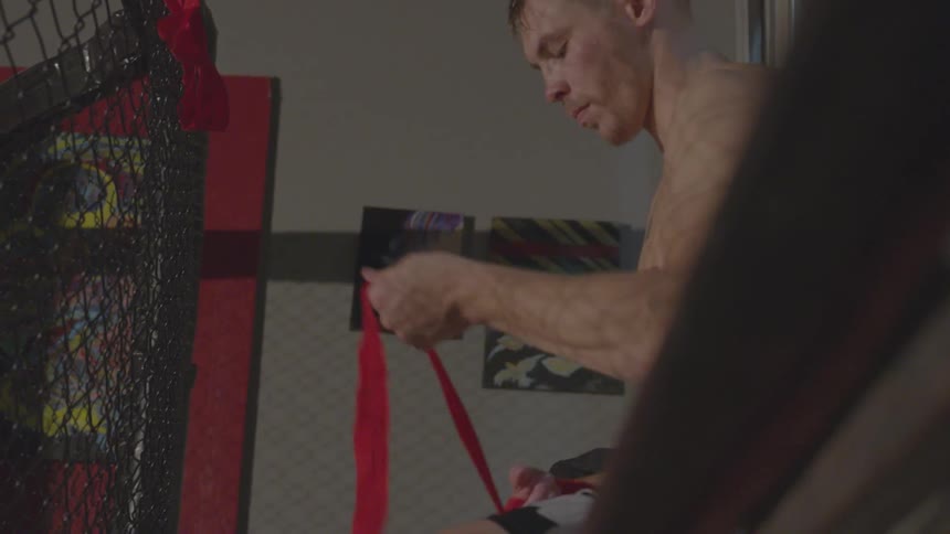 Man unwraps his wrist with a red bandage