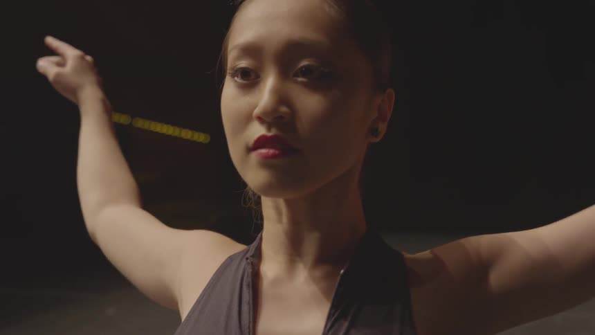 A ballerina stretches on a stage