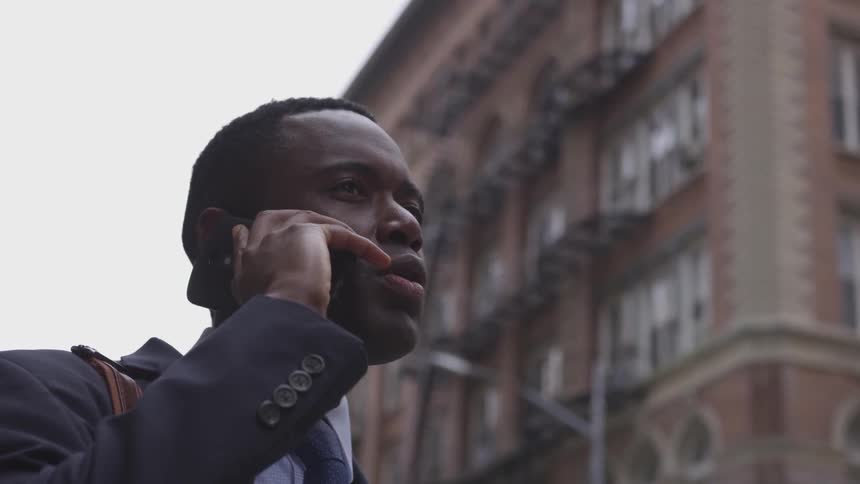 A man is talking on the phone in the large city
