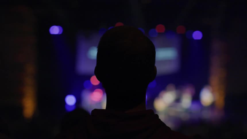 People in an audience watch a performance on a stage
