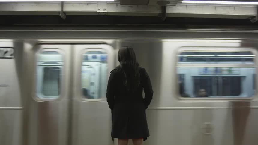 A woman waits for a subway train