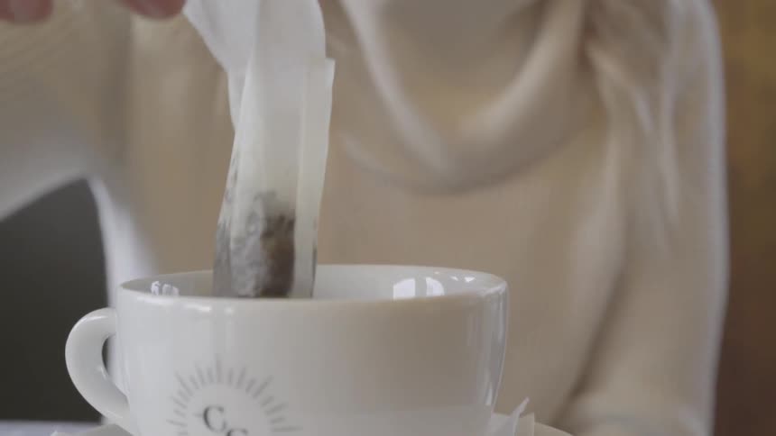 The person is dipping their tea bag