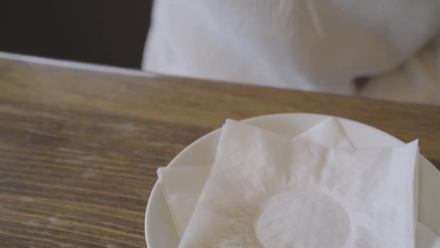 A woman picks up a mug of tea and then puts it back on a saucer
