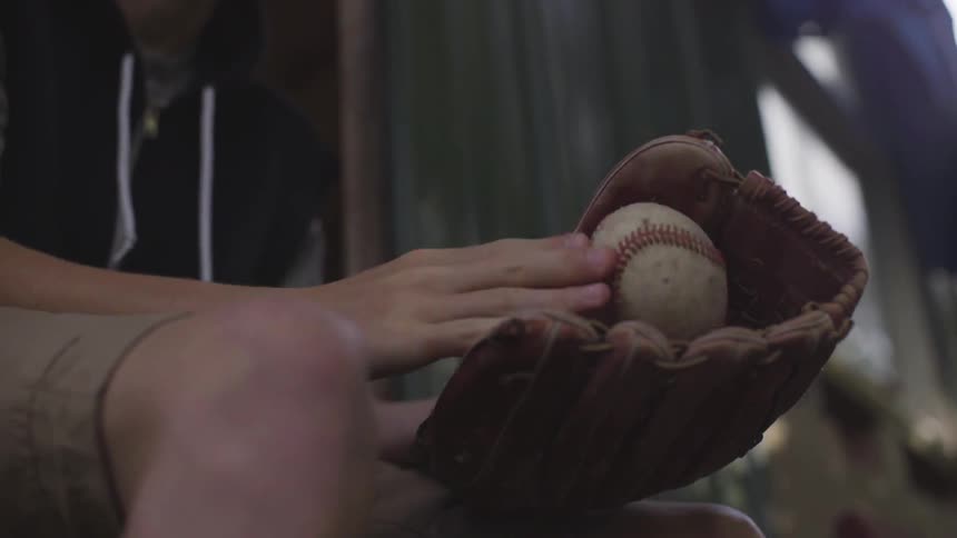 Child plays with a baseball throwing it into a mitt