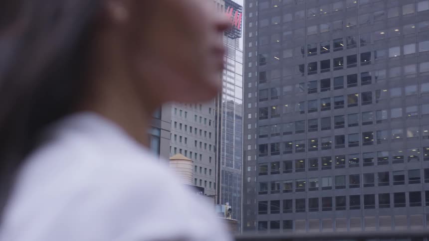 A woman looks around the city with tall buildings