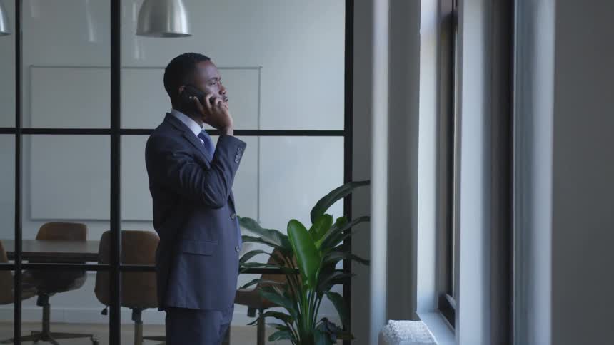 A businessman talks on a phone in an office