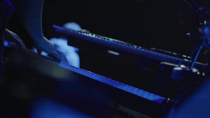 A man plays a keyboard on stage
