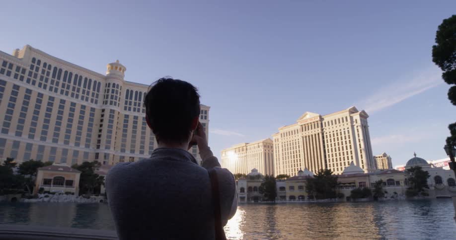 Woman takes a photo of the buildings with her cellphone