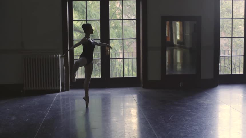 A ballerina pirouettes in a dance studio