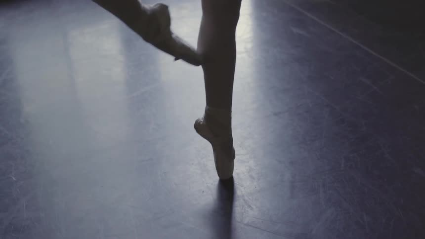 A ballerina pirouettes en pointe
