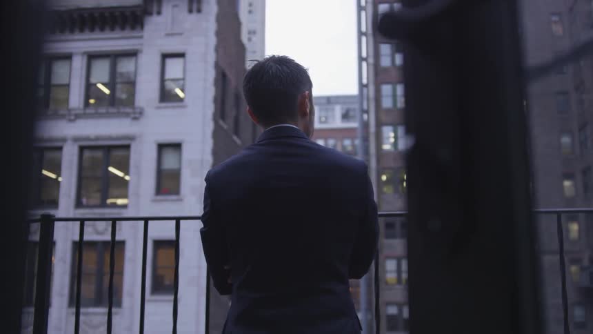 A man stand son the balcony on a cloudy day