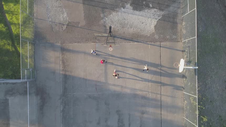 Men play basketball on an outdoor court