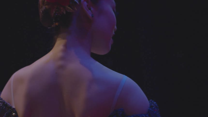 Woman turns around dancing on a stage