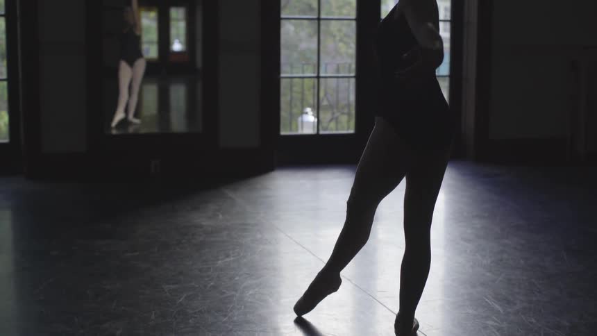 A woman is dancing in the dark room