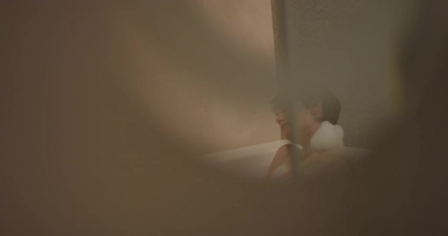 Woman bathes herself in a tub