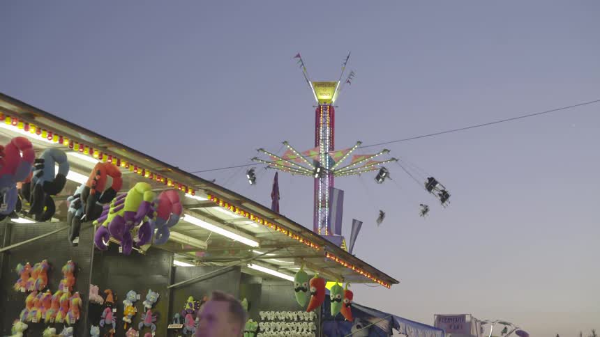 Fair ride spins around at sunset