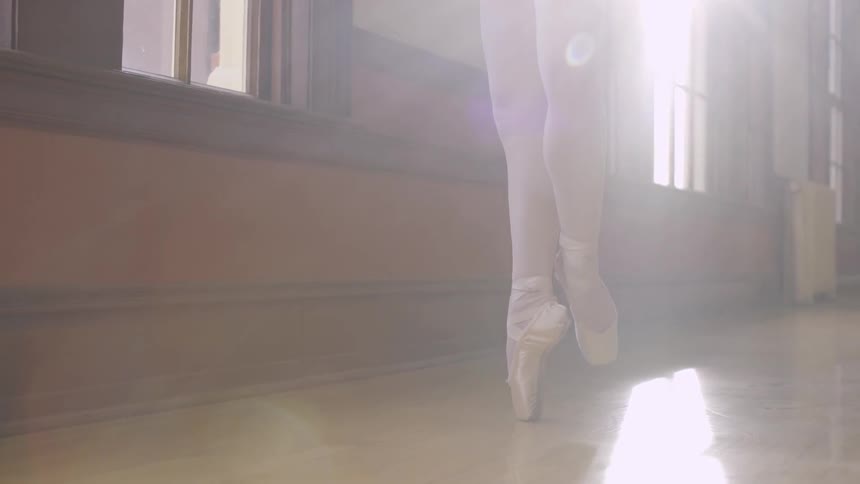 Woman stands on her tiptoes practicing ballet
