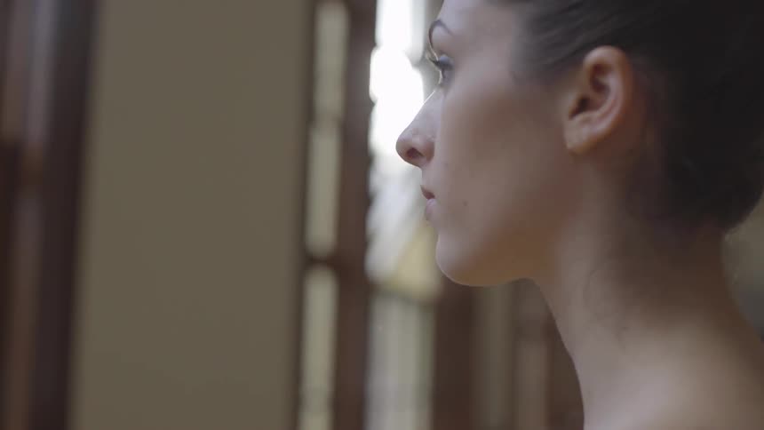 A ballerina stands in a dance studio