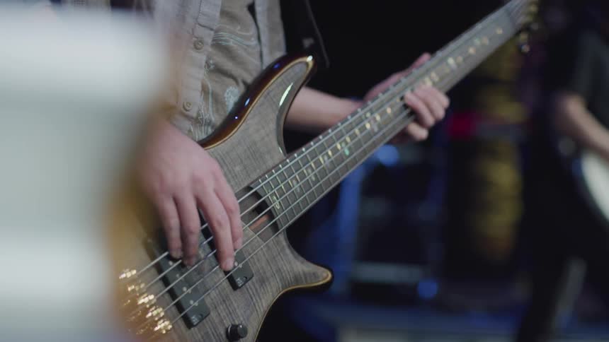 Person plays a bass guitar in a band