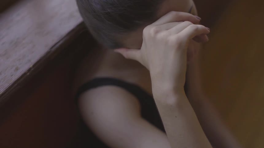 Woman leans against a window ledge