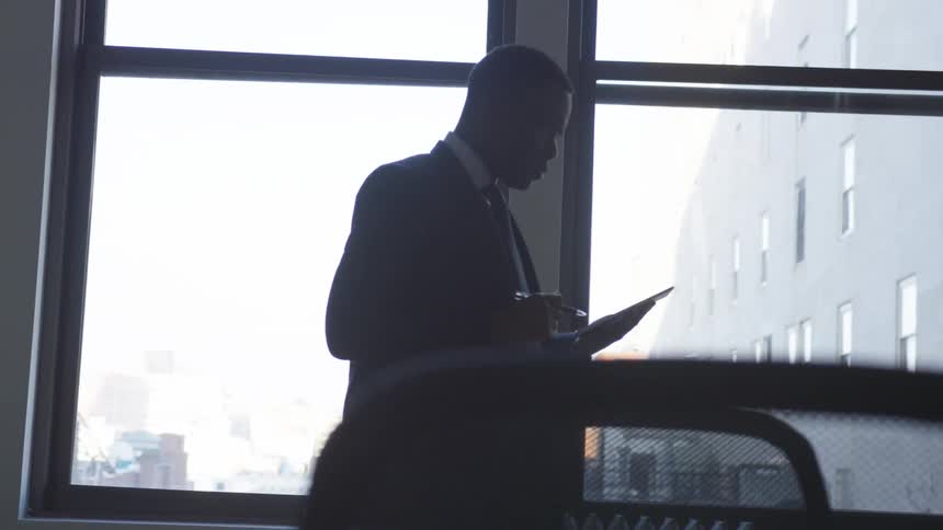 A businessman uses a tablet in an office