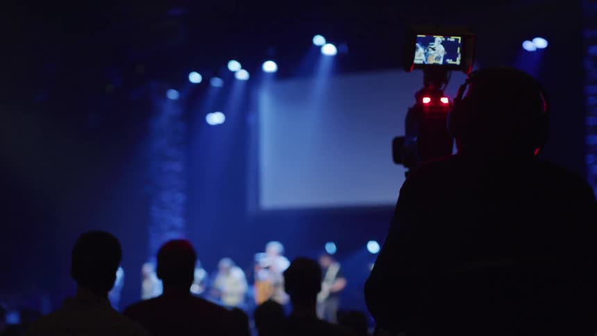An audience watches a band perform on stage