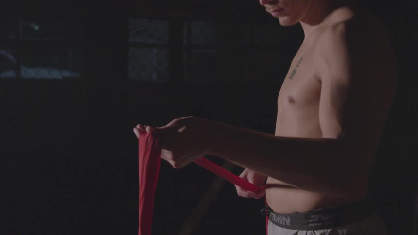 A man lifts the red hand wrap in the gym
