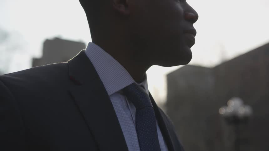 A businessman stands outside in a city