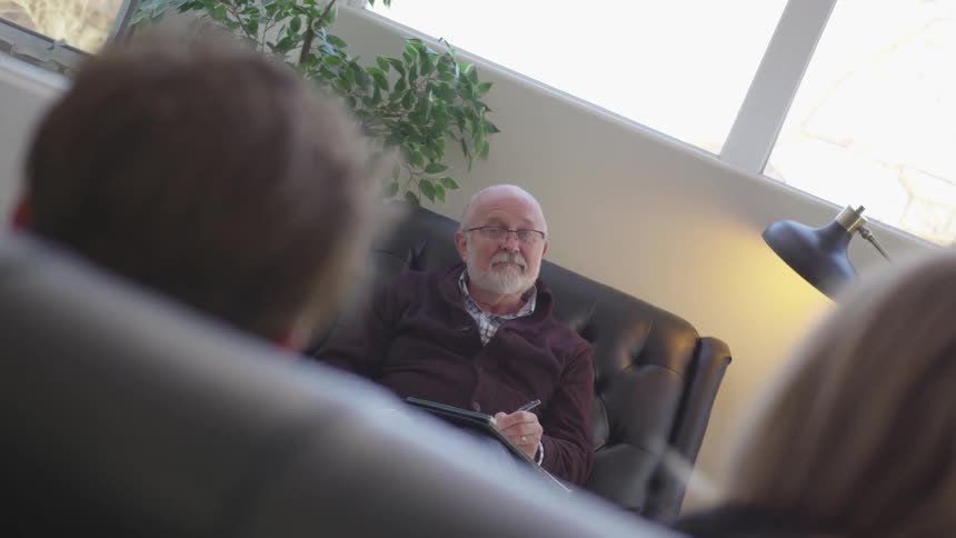 Therapist is talking to man and woman in sunny office