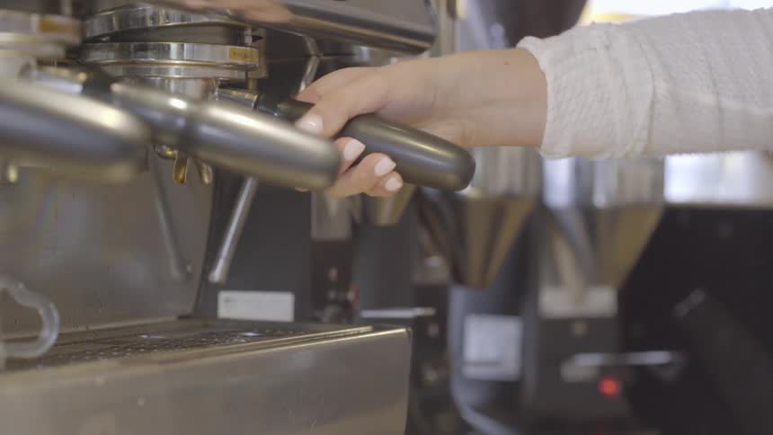 A person attaches a handle to a machine