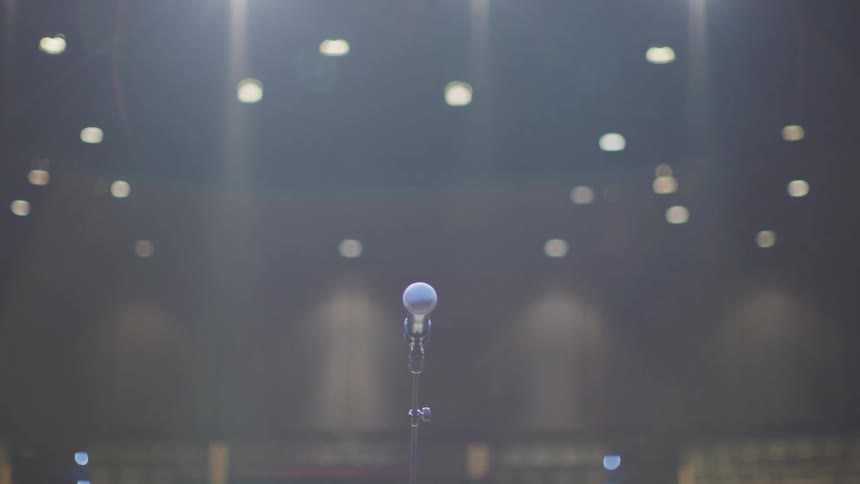 A microphone stands on a stage