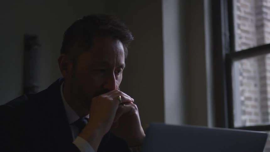 A businessman works on a laptop in an office