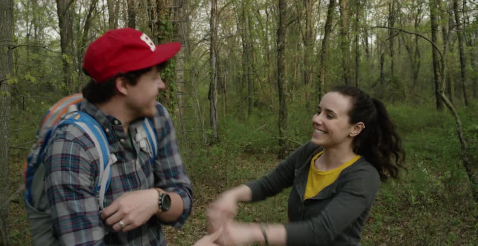 Man and woman are kissing outdoors in a forest
