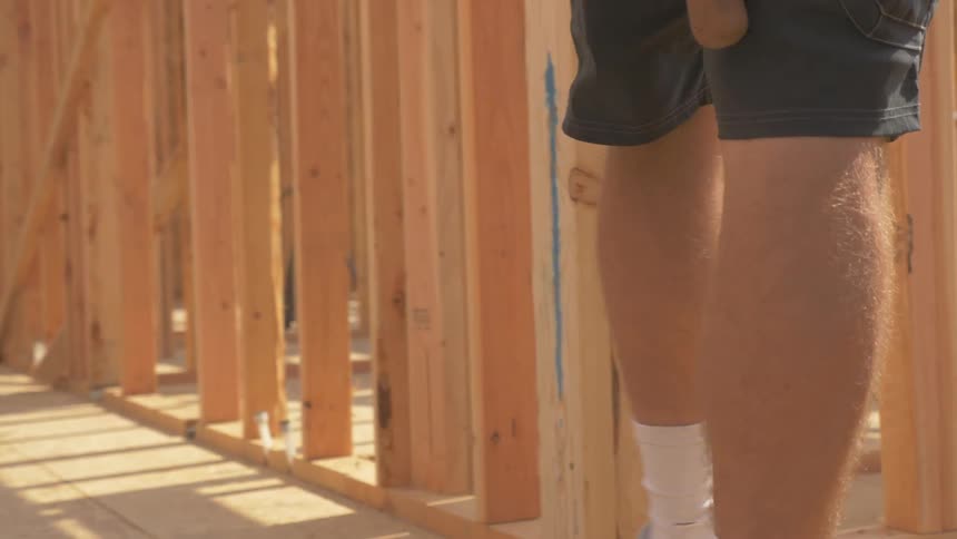 Man walks through a construction site on a sunny day