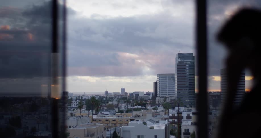 A woman talks as large clouds move over the city