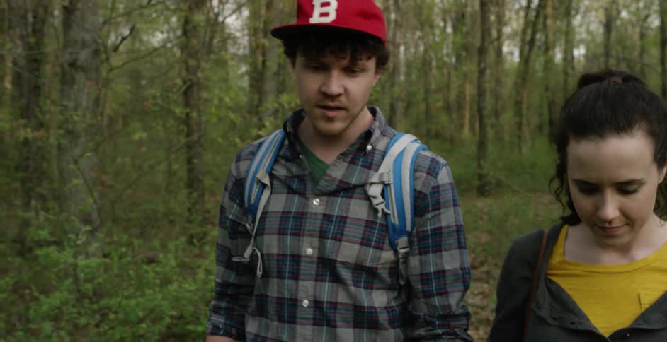 Two people holding hands and walking in a forest