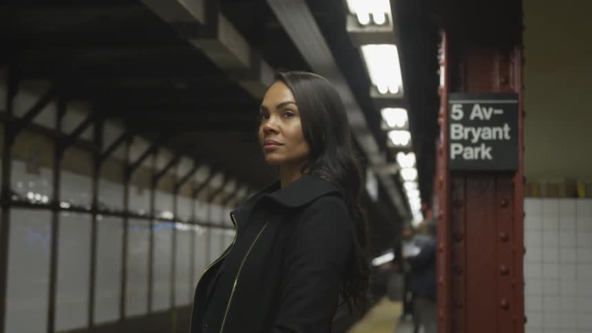 A woman waits for a subway train