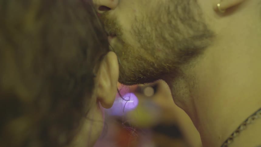 A man and woman kiss each others foreheads at a carnival