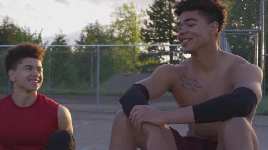 Men sit together on the court talking