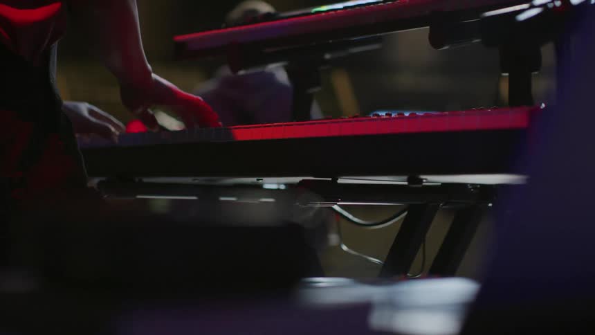 A man plays a keyboard on stage