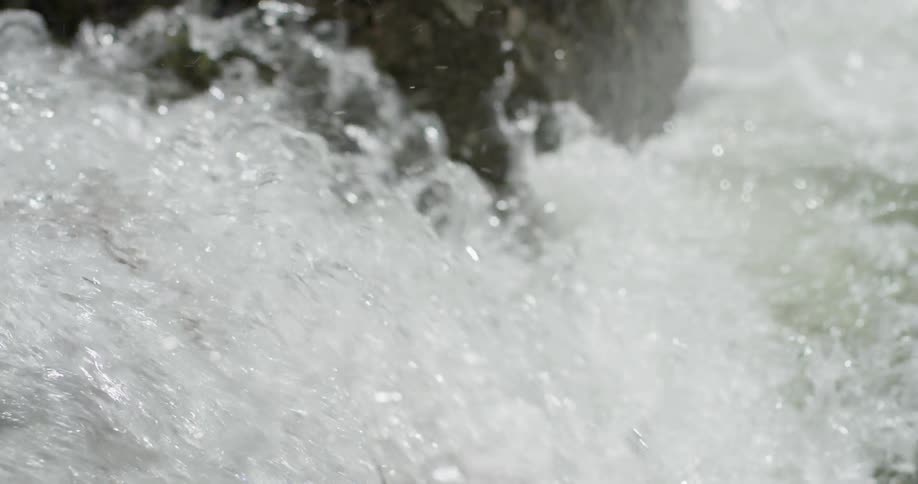 River water gushes over a rock