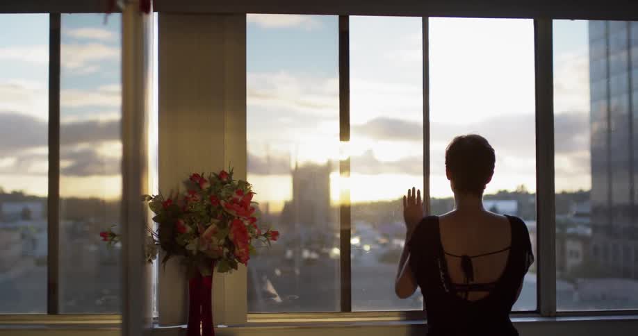 Woman slides open a window and then walks away
