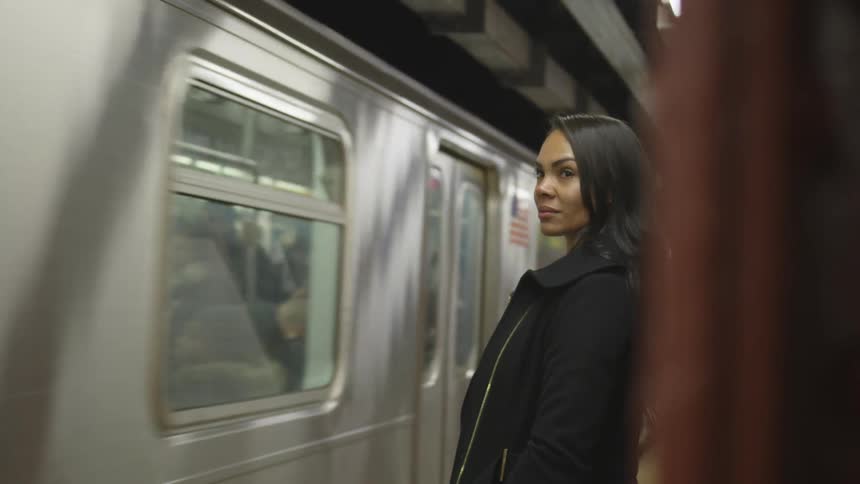 The train passes the smiling woman in the subway