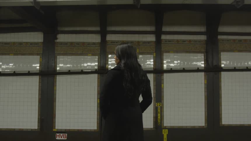 A woman waits for a subway train