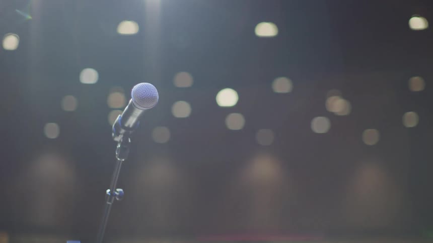 A microphone stands on a stage