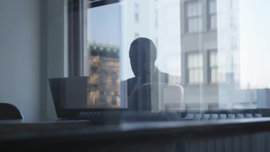 A businessman works on a laptop in an office