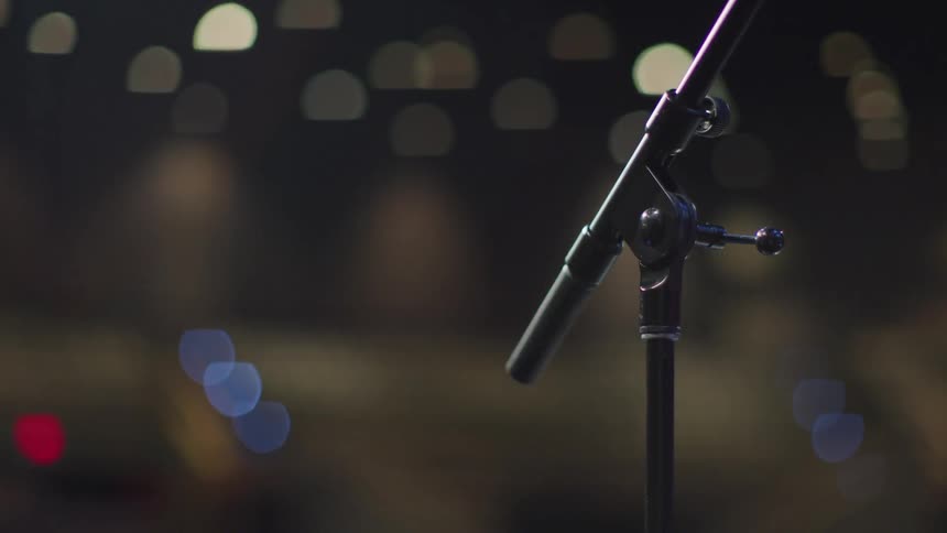 A microphone stands on a stage