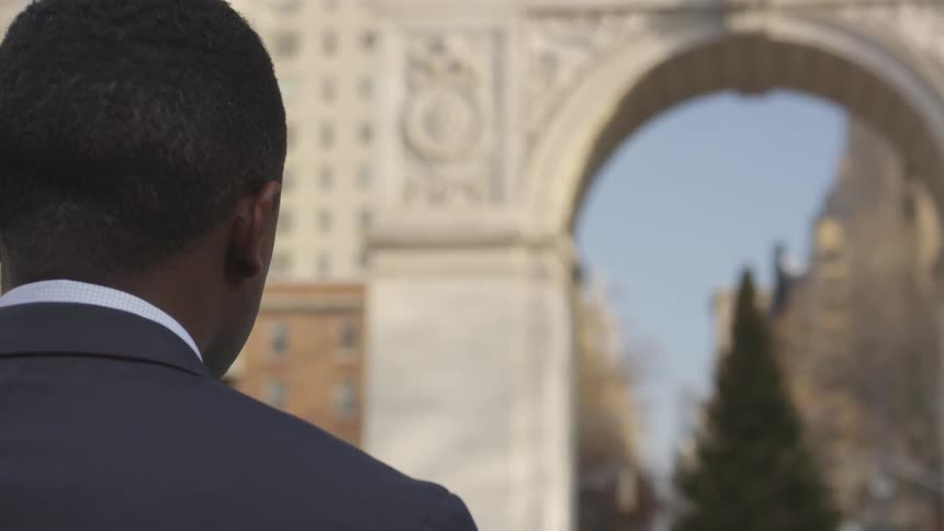 A businessman stands in a city