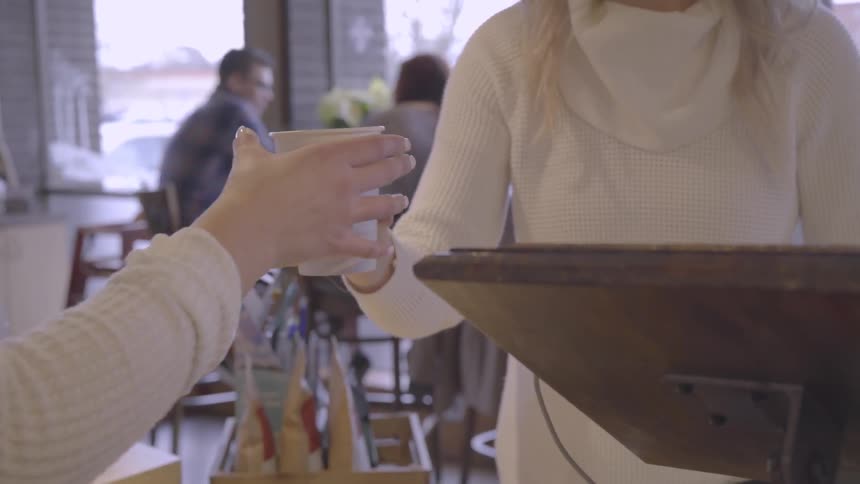 The customer receives a beverage in the shop