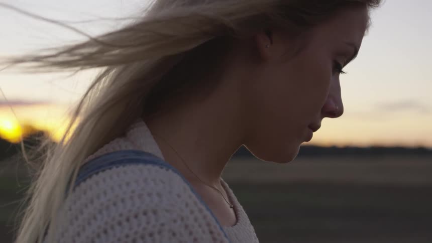 A woman walks at dawn on a windy day